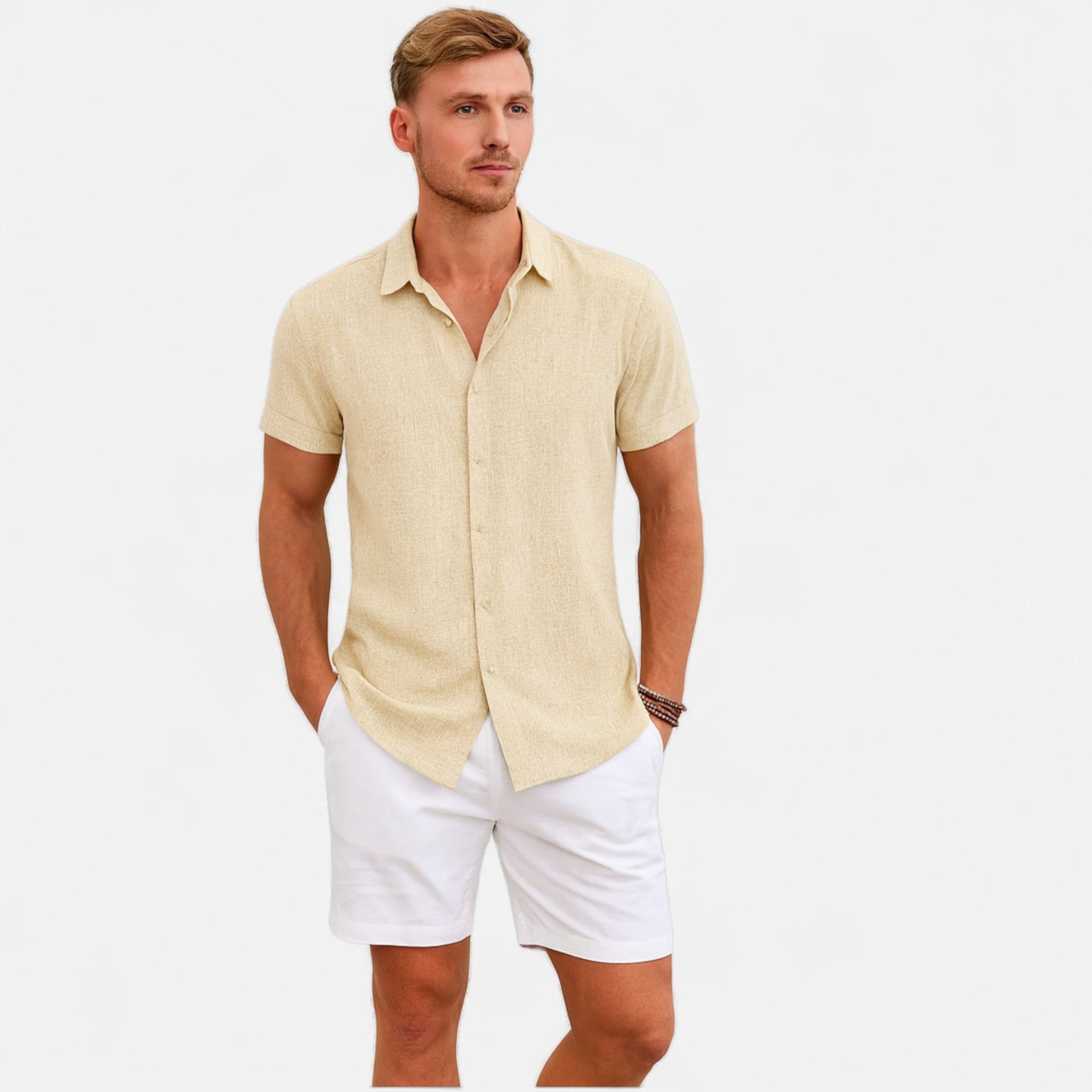 Man wearing a light-colored short-sleeve shirt and white shorts on a plain background