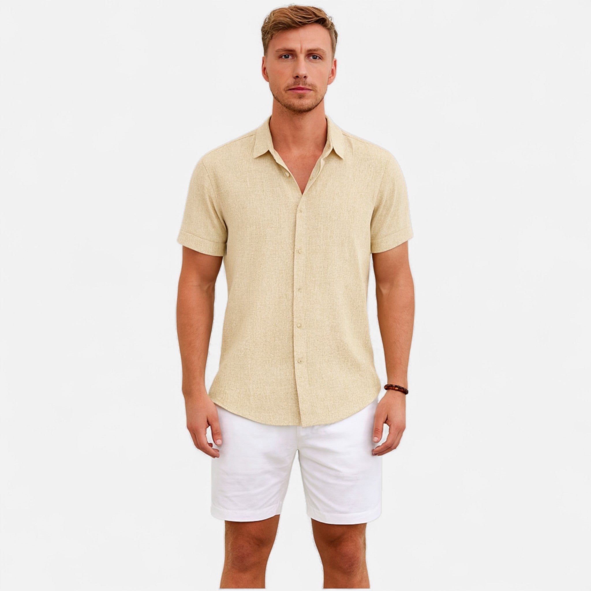 Man wearing a beige short-sleeve shirt and white shorts on a light gray background