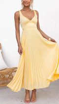Woman wearing a yellow pleated dress on a white background