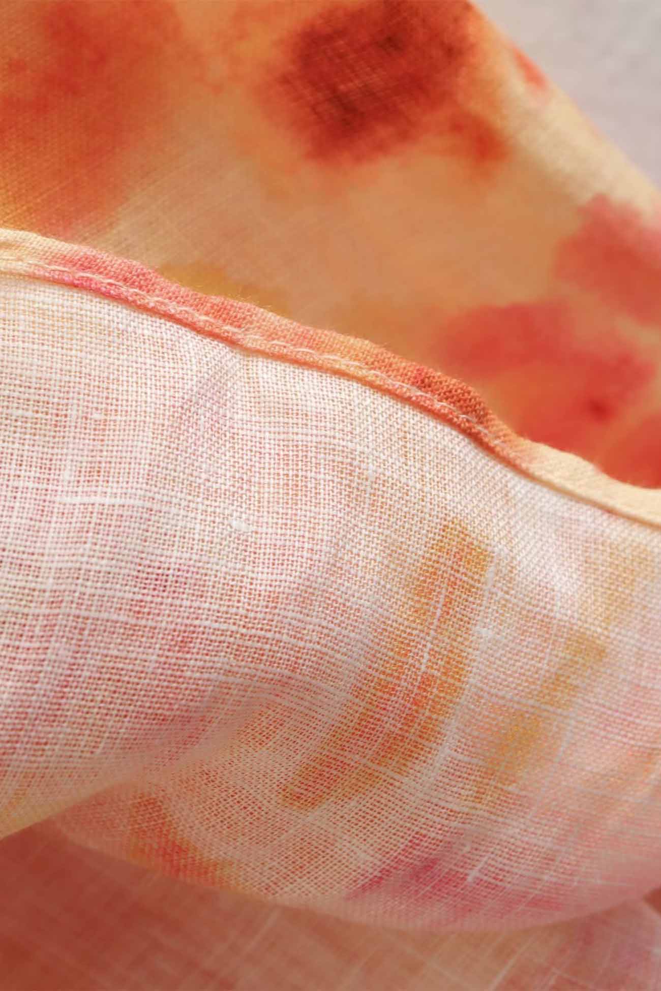 Close-up of fabric with orange and pink watercolor pattern