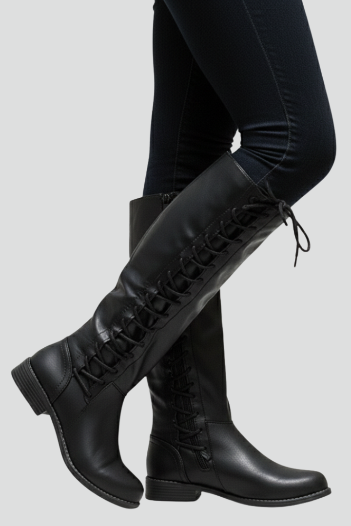 Black knee-high boots worn with black leggings on a light gray background