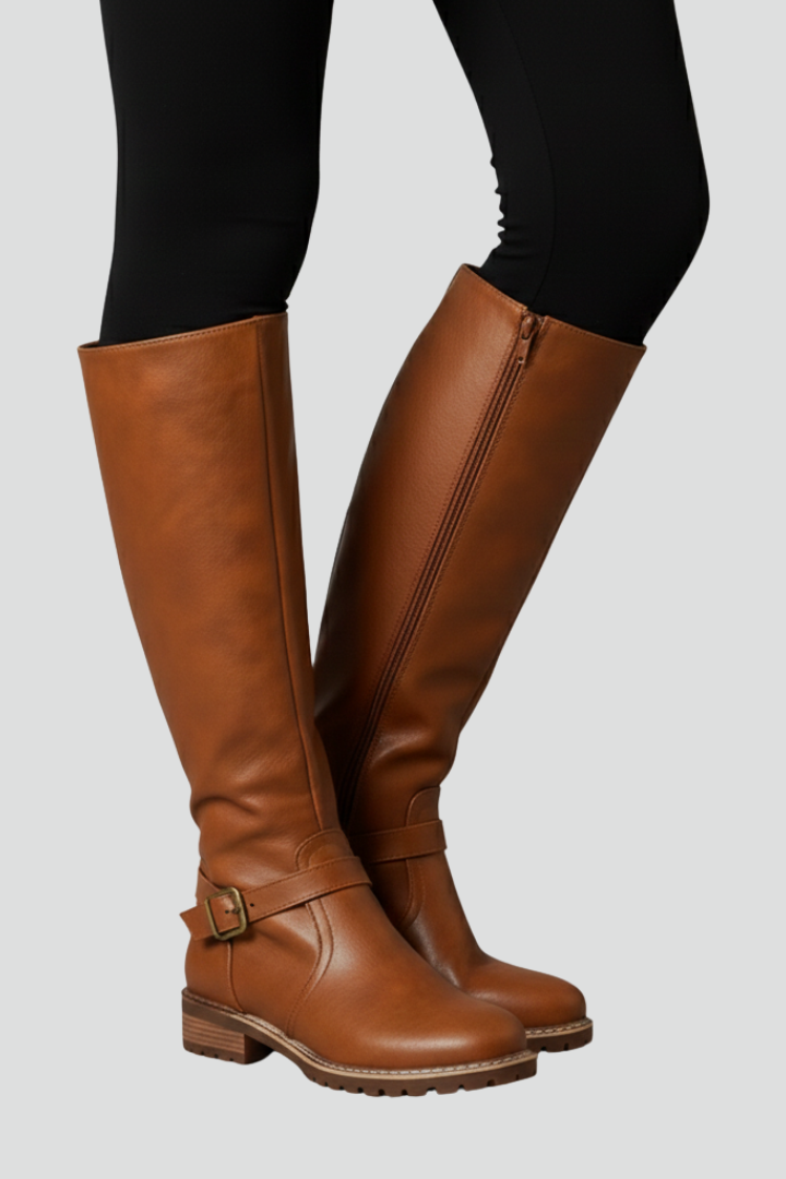 Brown knee-high boots worn with black leggings on a light gray background