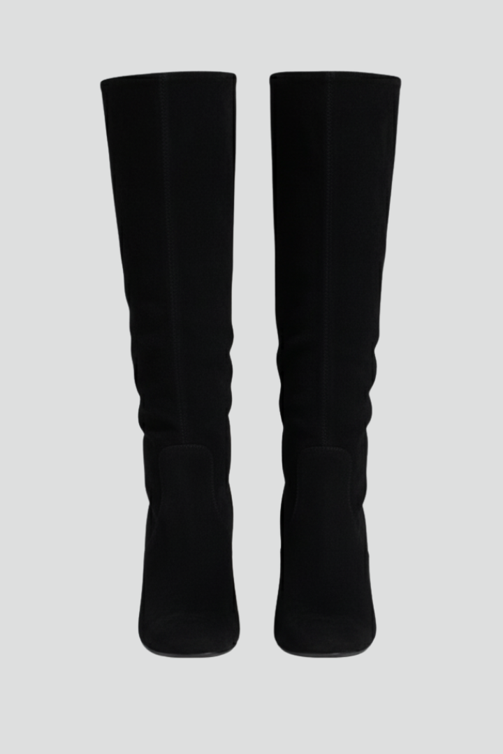 Pair of black knee-high boots on a light gray background