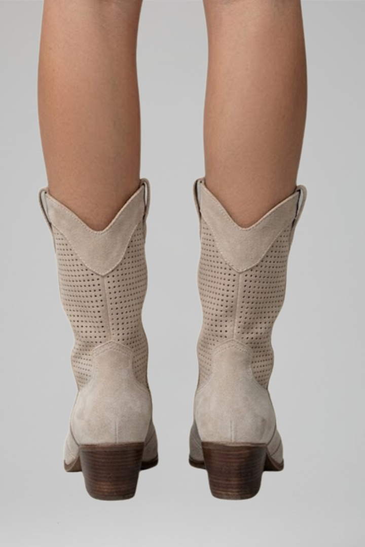 Beige cowboy boots on a plain background