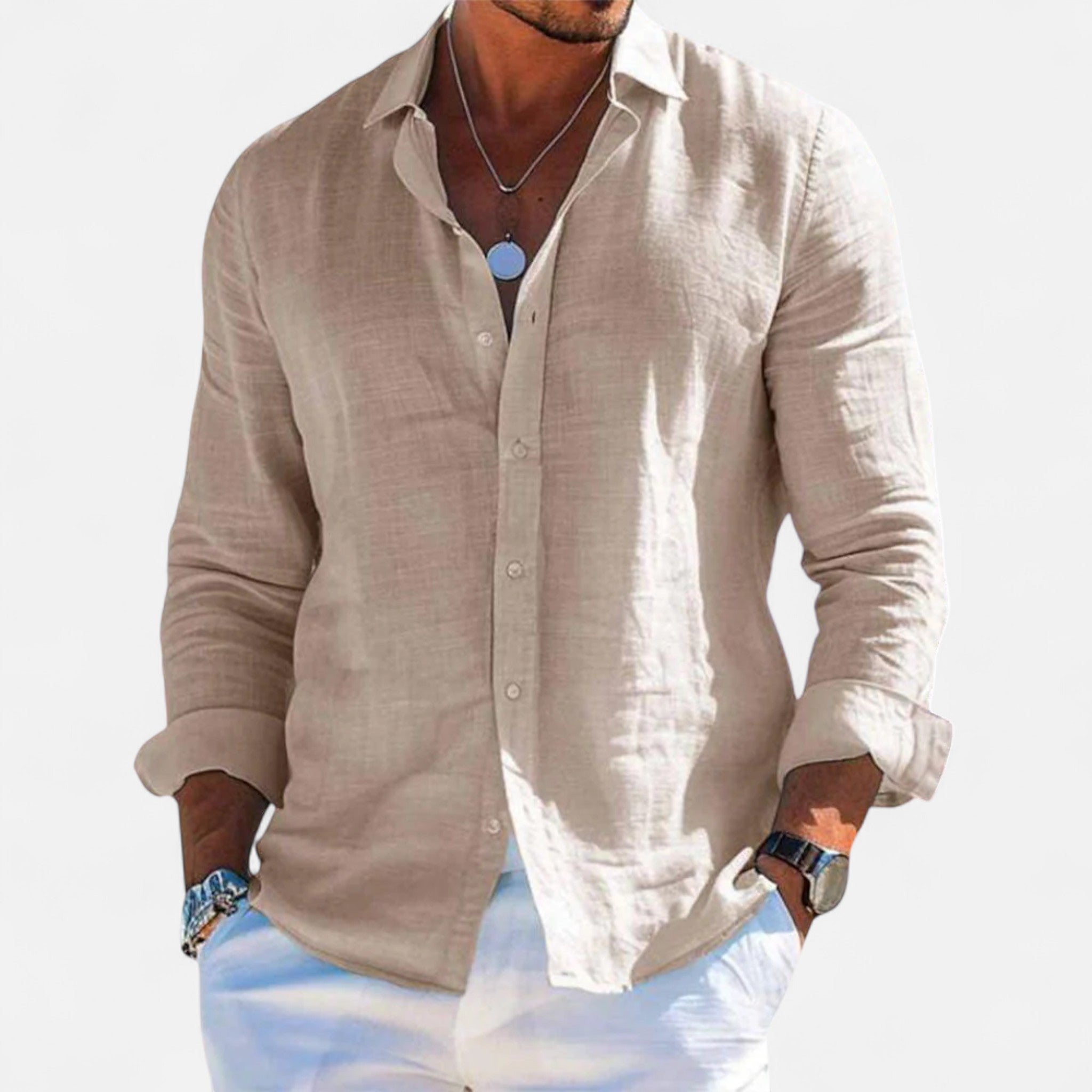Man wearing a beige linen shirt with rolled-up sleeves on a light background