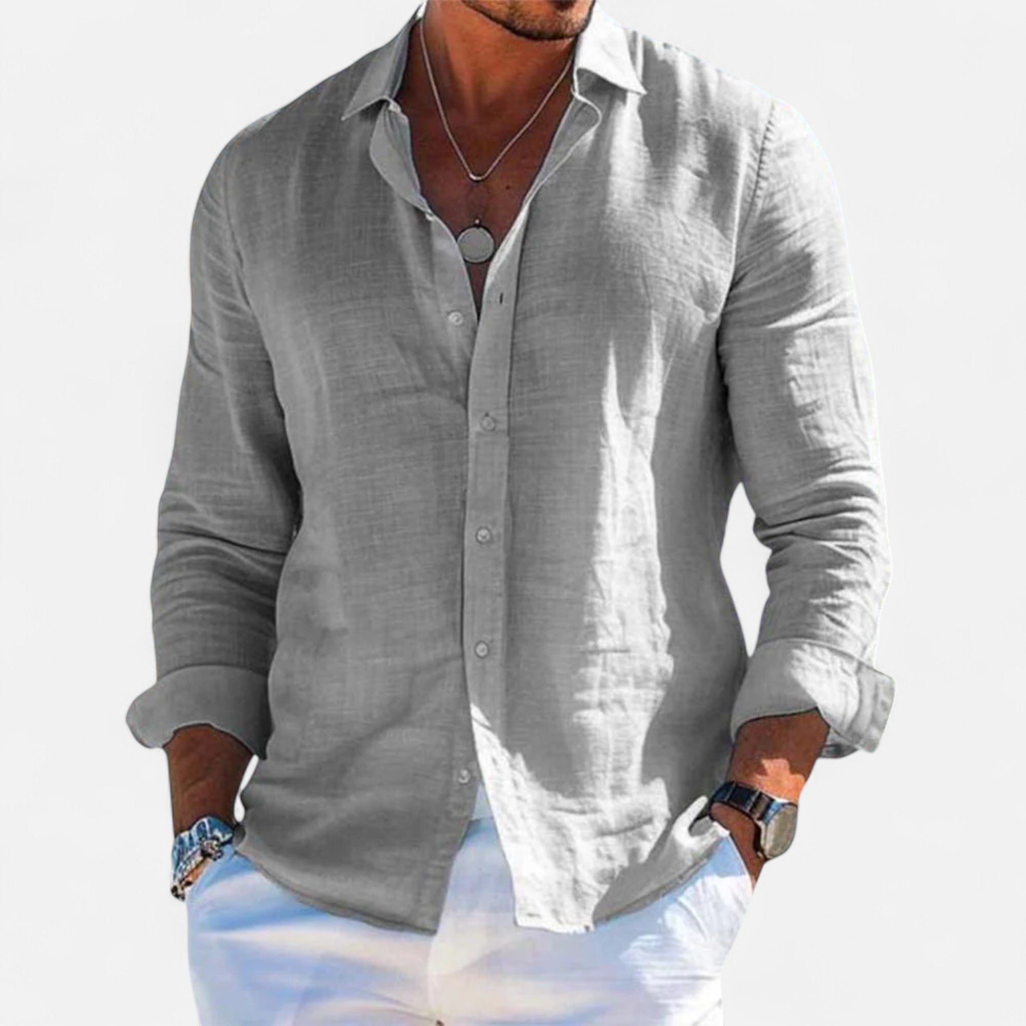 Man wearing a gray linen shirt with rolled-up sleeves on a light gray background
