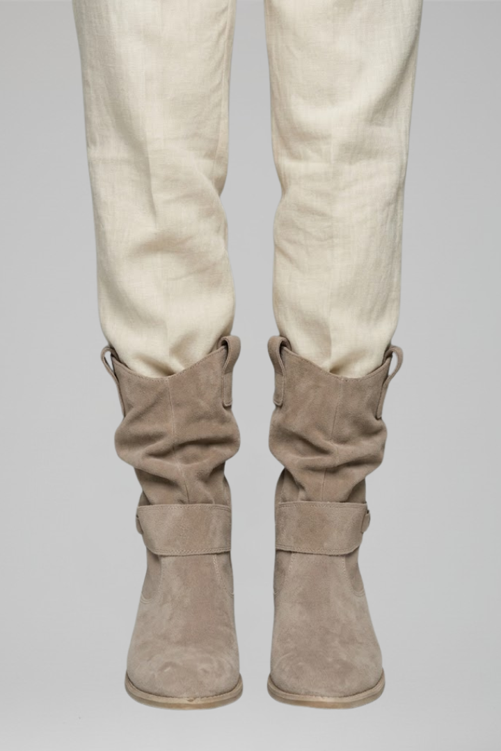 Beige pants with brown boots on a gray background