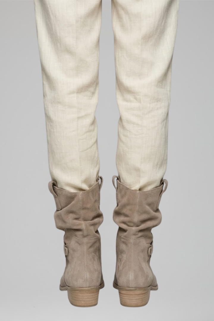 Beige pants with brown boots on a gray background