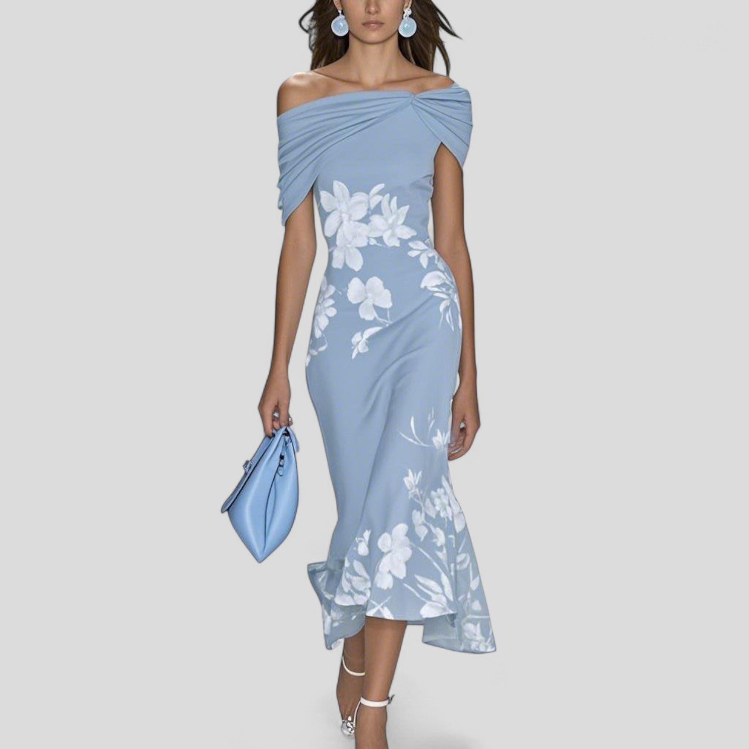 Woman wearing a light blue off-shoulder dress with floral patterns on a plain background