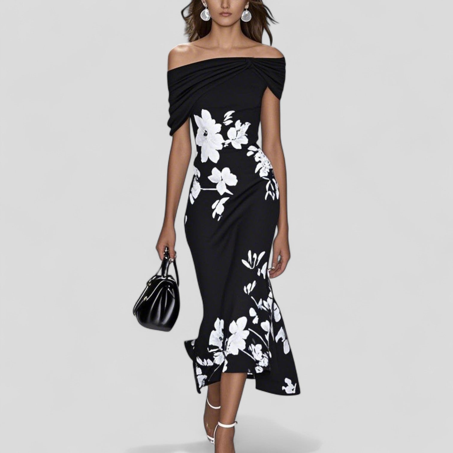 Woman wearing a black off-shoulder dress with white floral patterns on a gray background