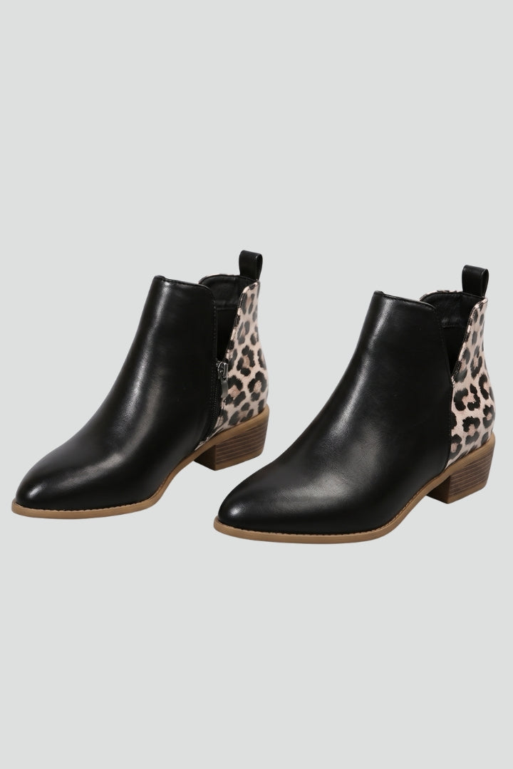 Black ankle boots with leopard print accents on a light gray background