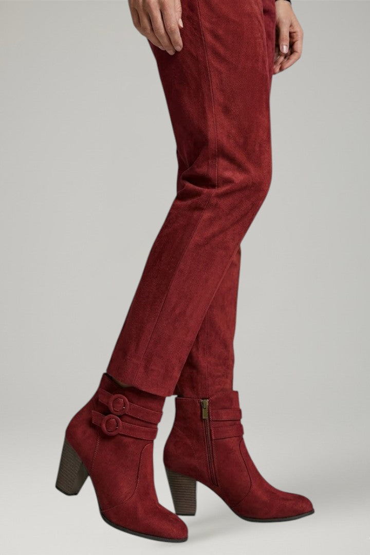 Red suede boots and pants on a plain background