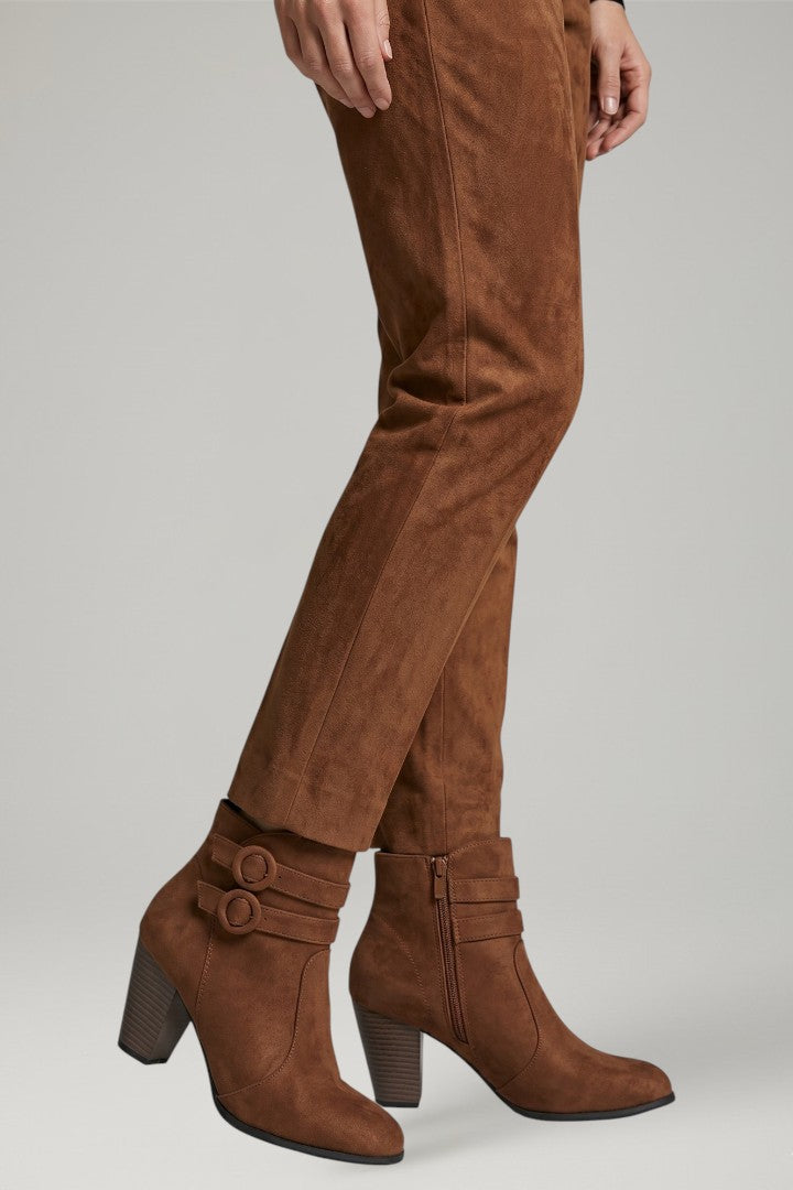 Brown suede boots and pants on a plain background