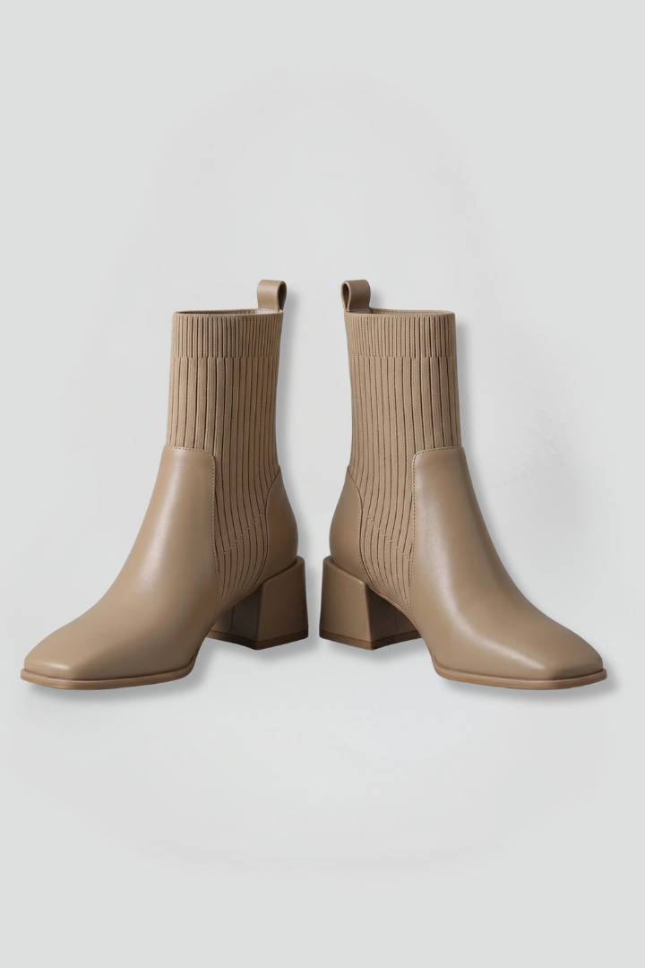 Pair of beige ankle boots on a light gray background