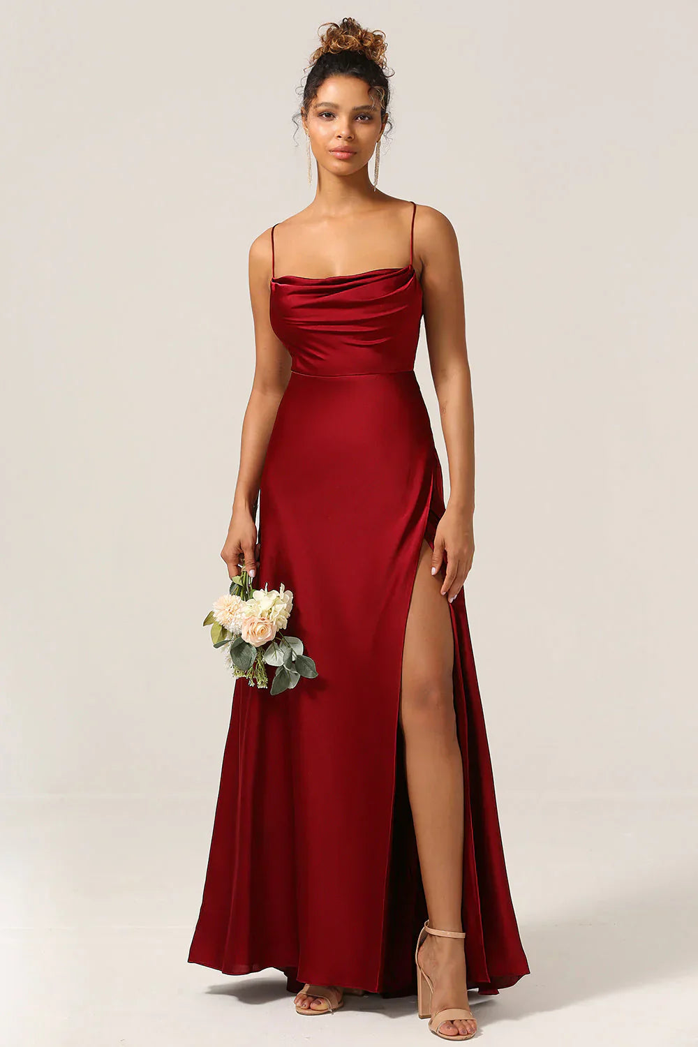 Woman wearing a red evening gown with a slit on a white background