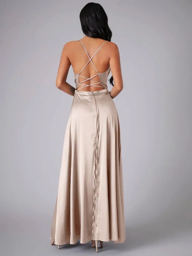Woman wearing a beige evening gown with a backless design on a gray background