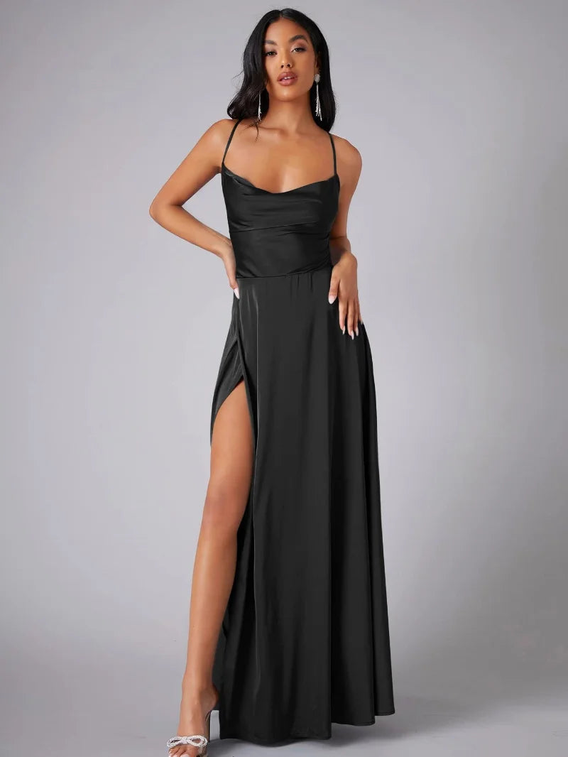 Woman wearing a black evening gown with a high slit on a gray background
