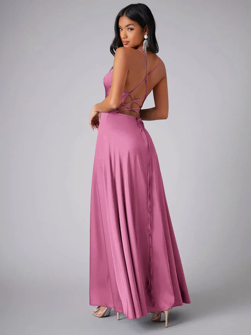 Woman wearing a pink evening gown with a backless design on a gray background