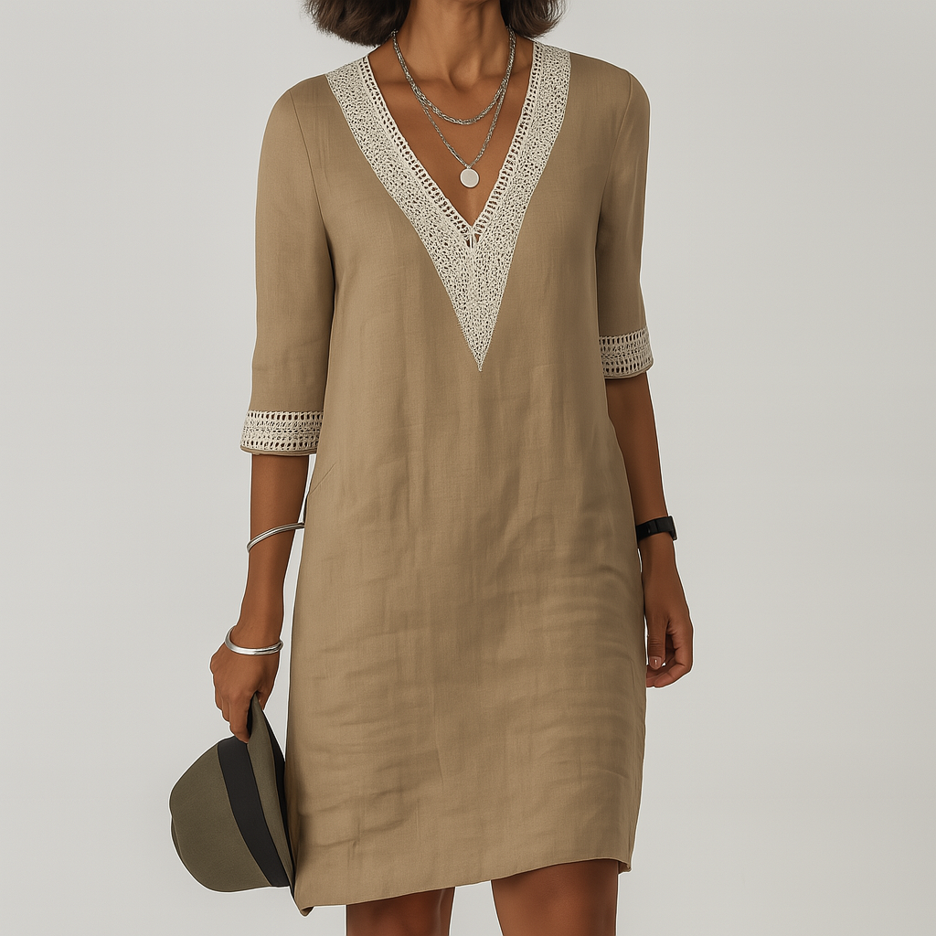 Woman wearing a beige dress with lace details on a plain background