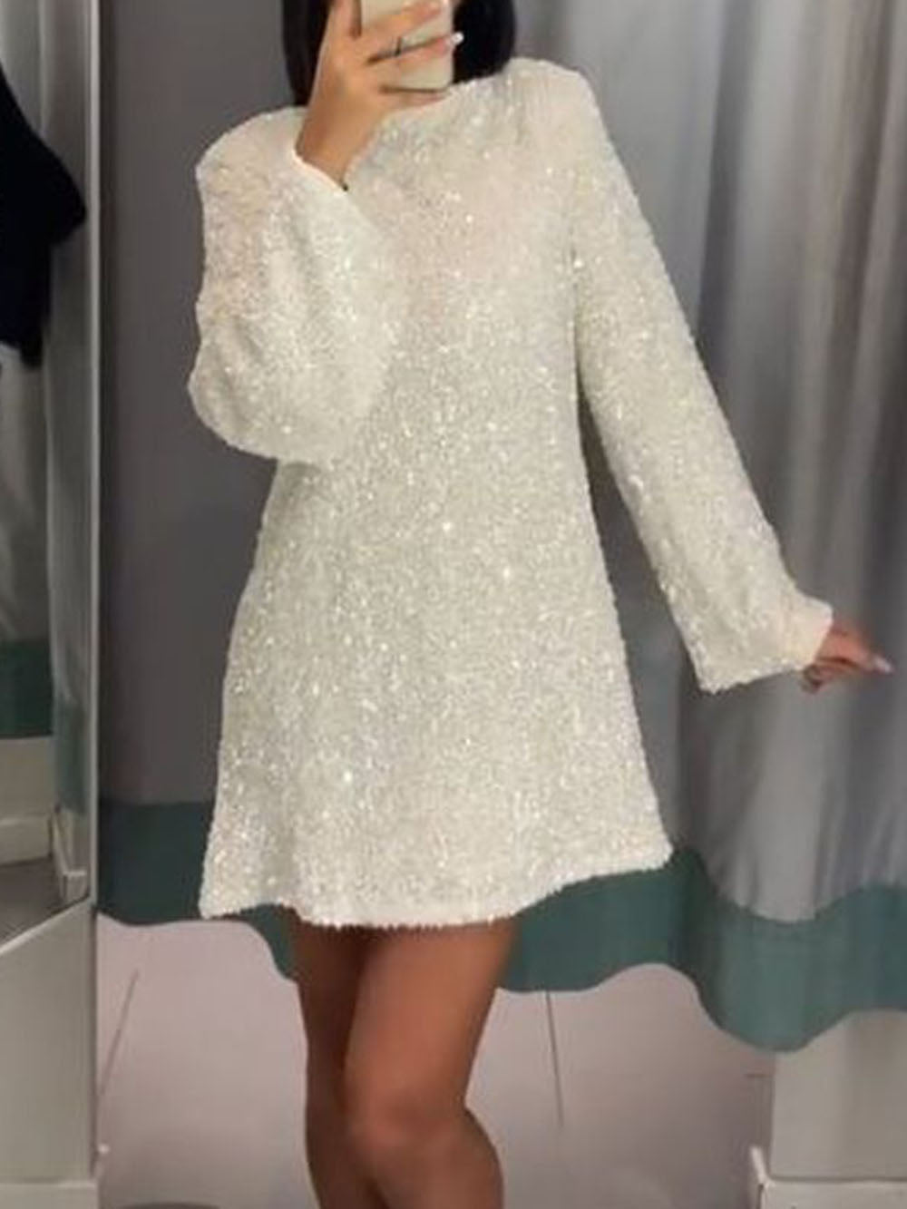 Person wearing a white textured dress against a neutral background