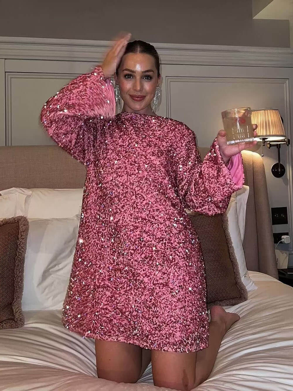 Person wearing a pink sequin dress in a bedroom setting