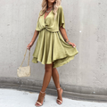 Woman wearing a green dress against a gray wall