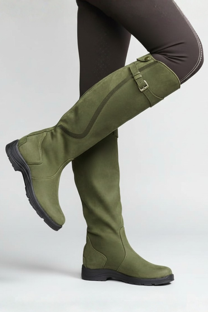 Green riding boots worn with dark leggings on a white background