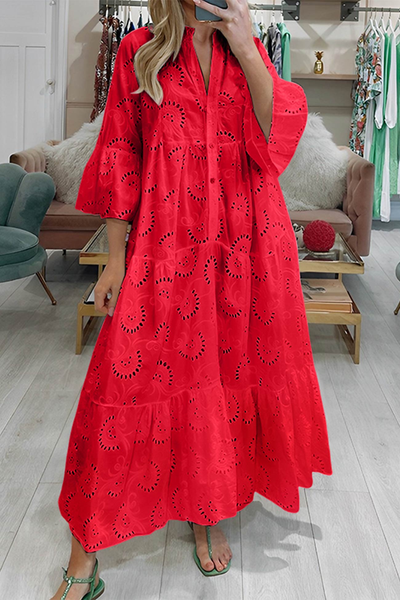 Woman wearing a red dress with cut-out patterns in a store setting.