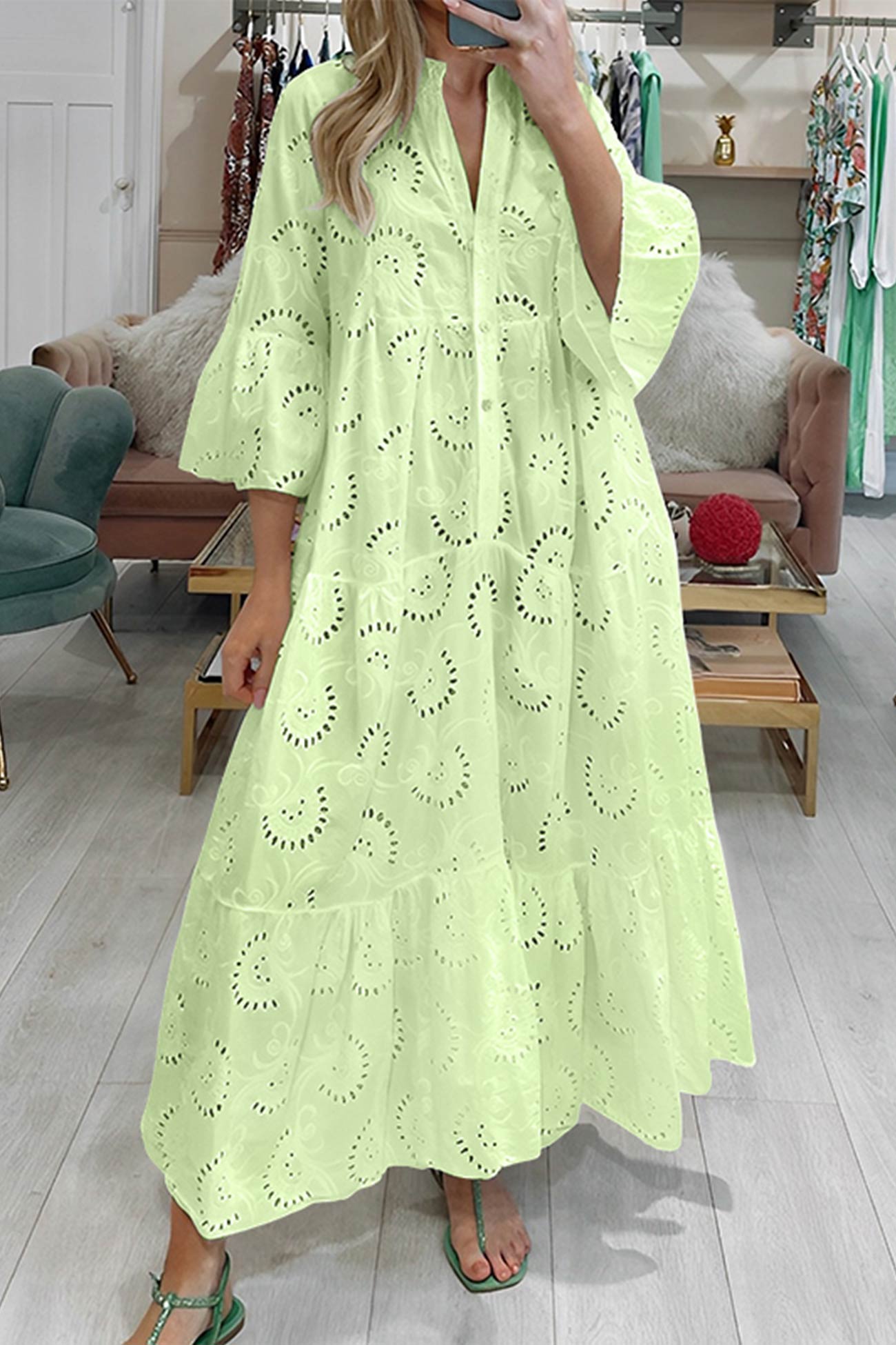 Person wearing a light green lace dress in a store setting