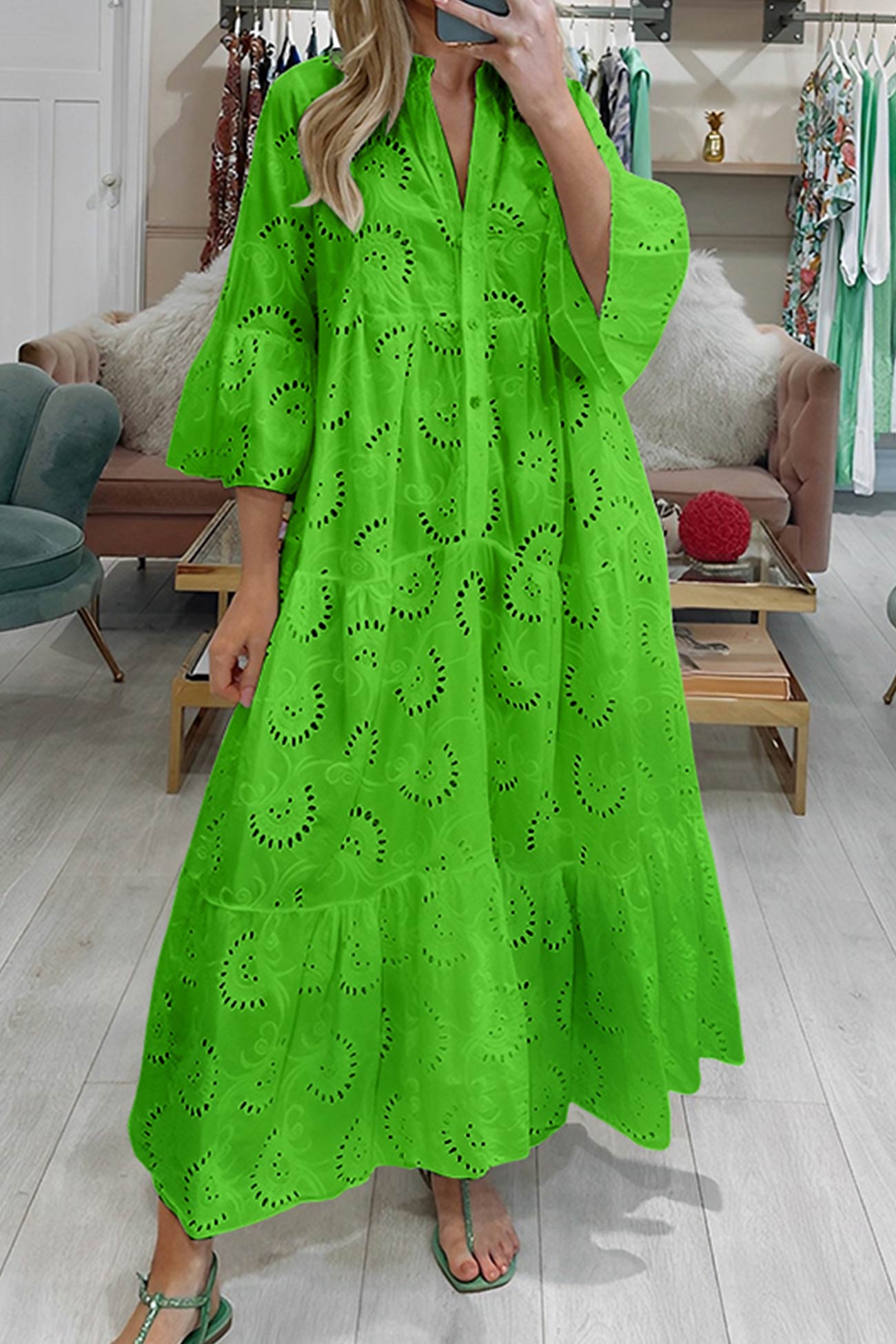 Person wearing a bright green dress with cut-out patterns in a store setting.