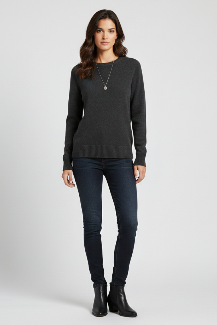 Woman wearing a black sweater and jeans on a white background