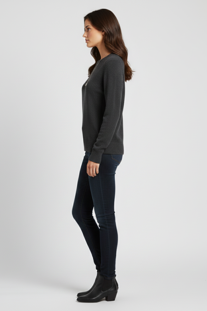 Woman wearing a dark gray sweater and black pants on a white background