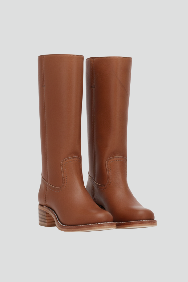 Pair of brown knee-high boots on a light gray background