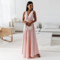 Woman in a pink dress standing in a modern living room.