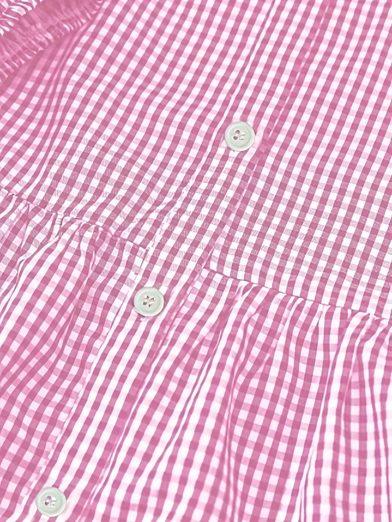 Close-up of a pink and white checkered fabric with buttons.