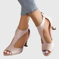 Beige open-toe high-heeled shoes worn with light blue jeans on a white background