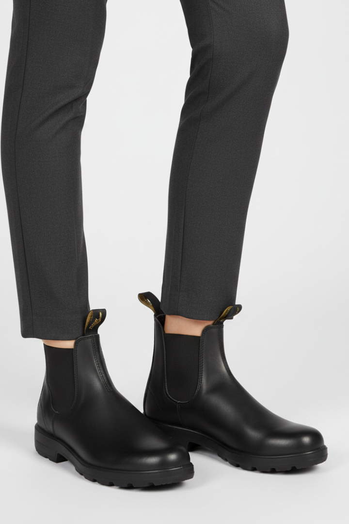 Black rubber boots worn with black pants on a white background