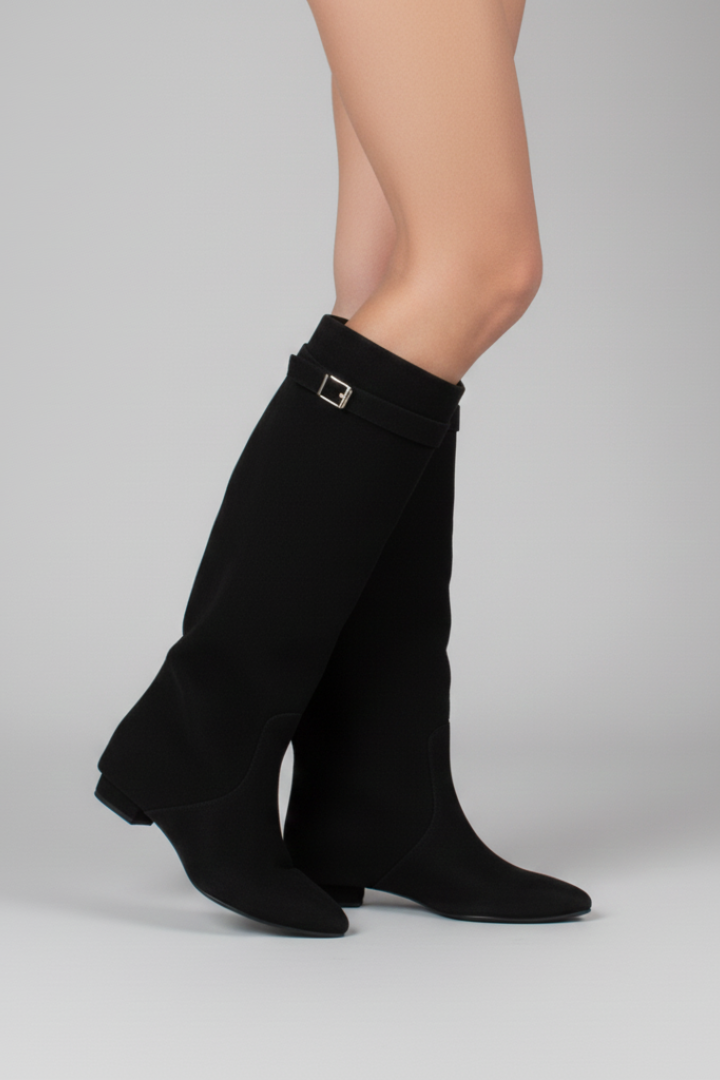 Black knee-high boots with ruffled design on a gray background
