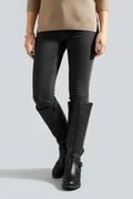 Person wearing black knee-high boots with a plain background
