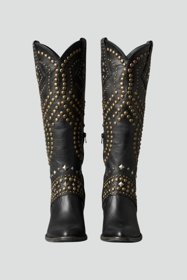 Pair of black studded boots on a light gray background