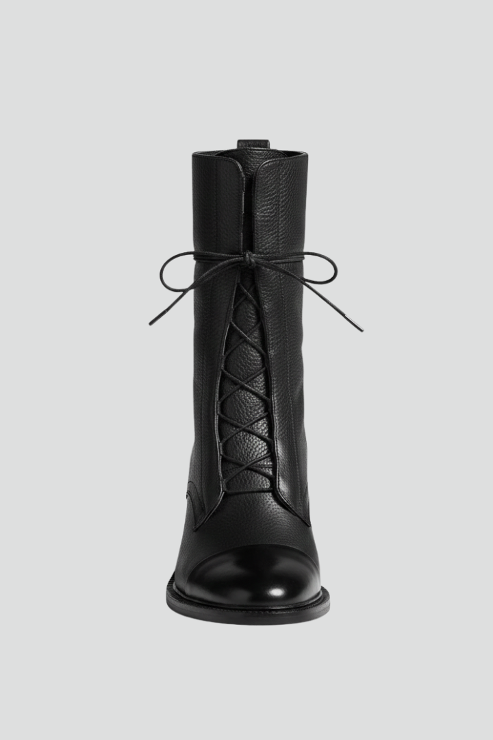 Black knee-high boot with lace-up design on a light gray background