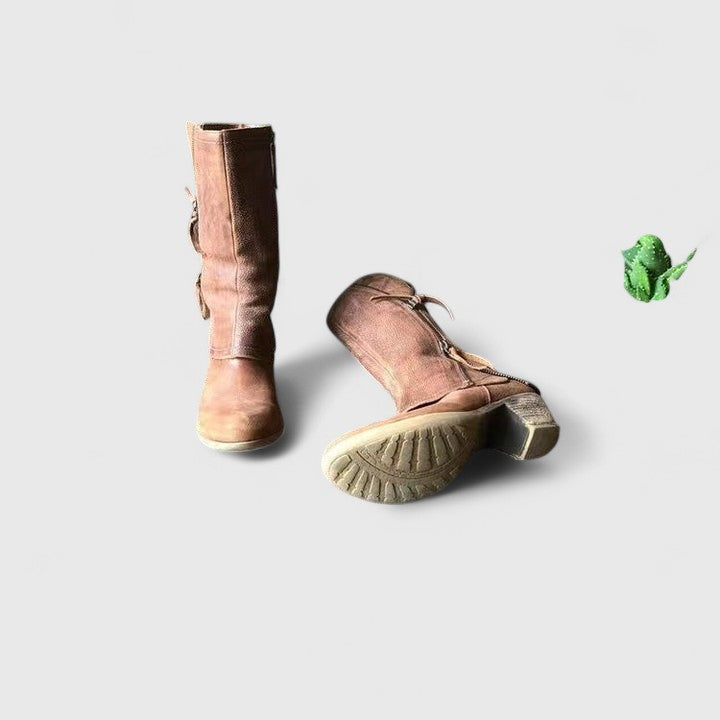 Pair of brown boots on a light gray background
