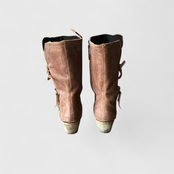 Pair of brown suede boots with lace-up design on a light gray background