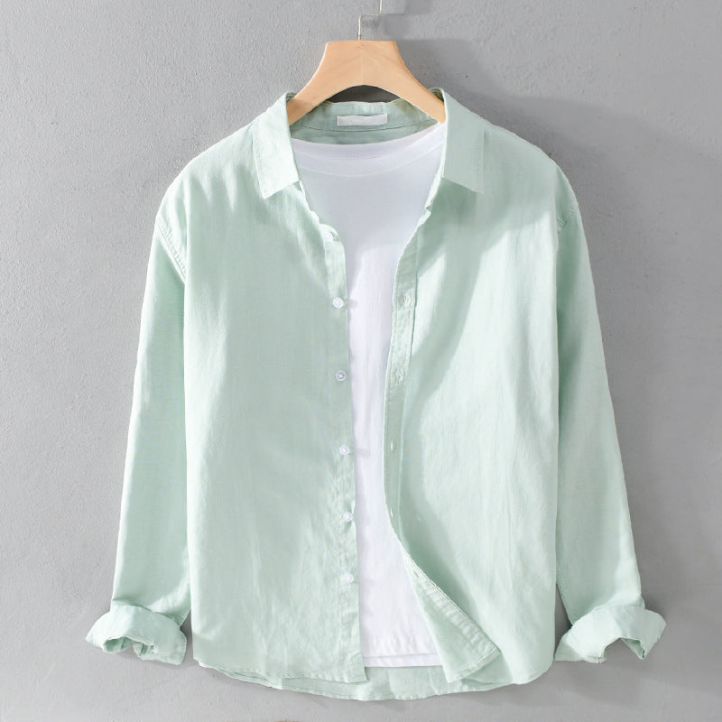 Light green shirt on a hanger against a gray background