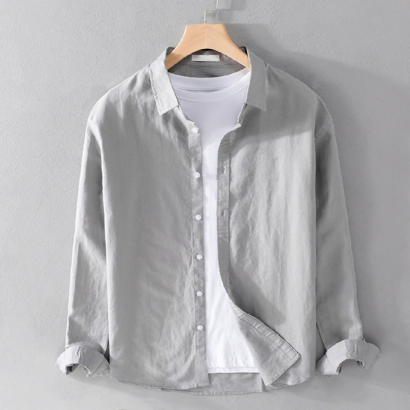 Light gray button-up shirt on a hanger against a gray background