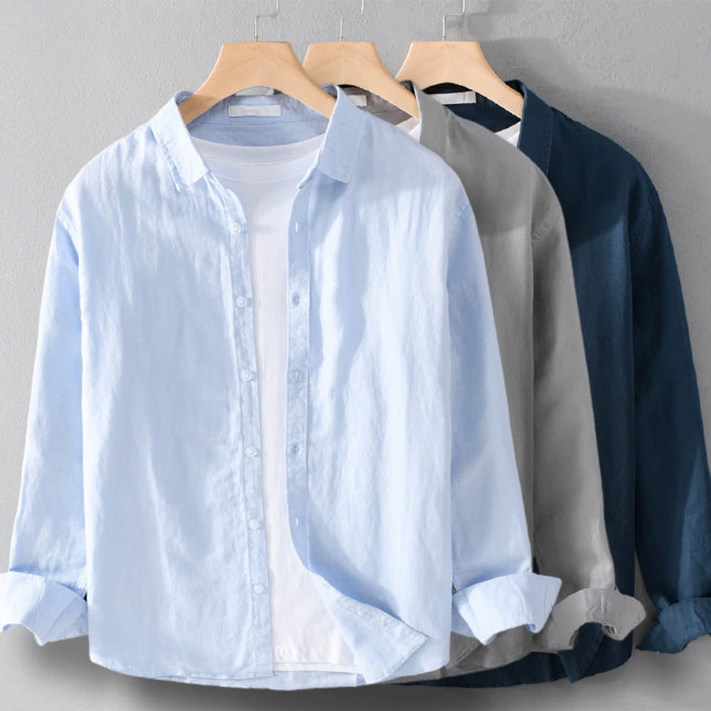 Light blue, gray, and navy shirts on hangers against a gray background