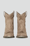 Pair of brown suede cowboy boots on a light gray background
