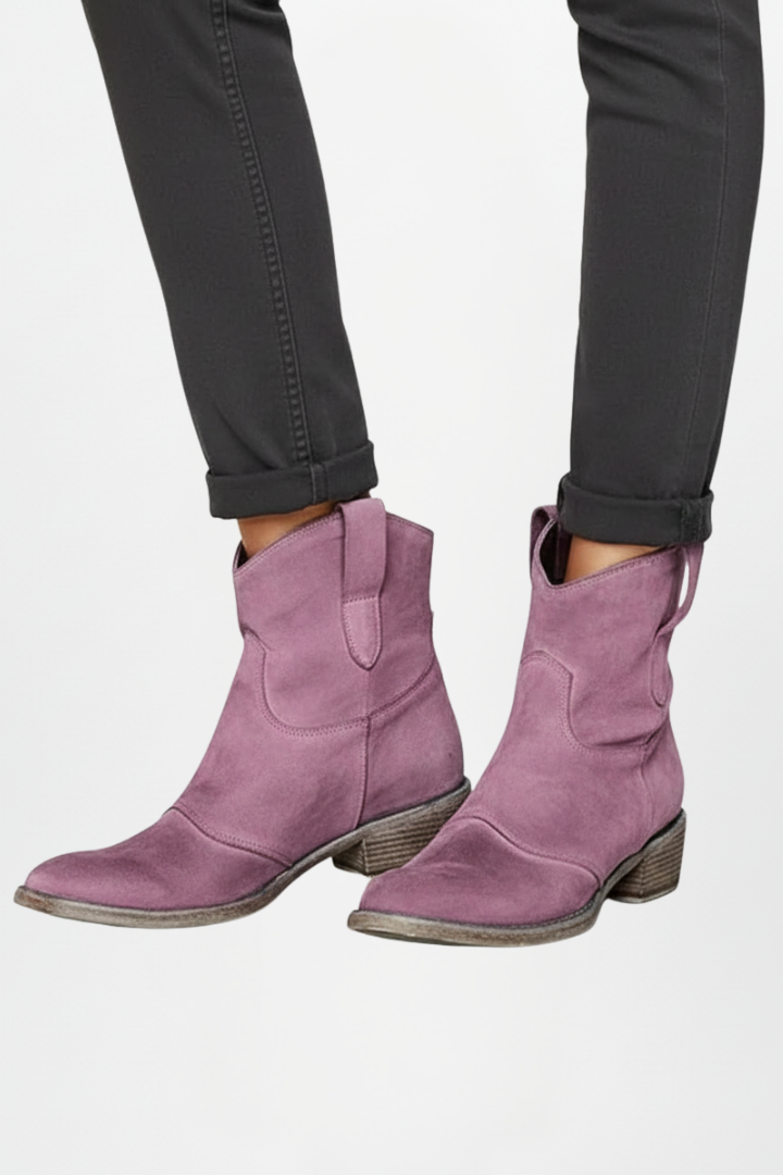 Purple boots worn with black pants on a white background