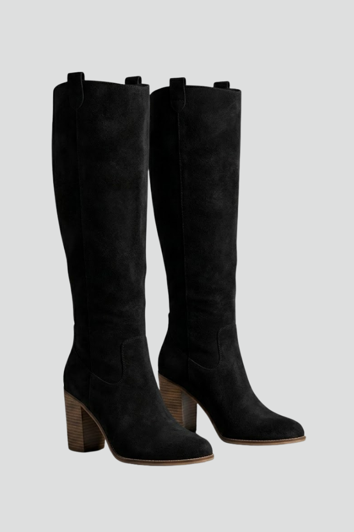 Black knee-high boots with wooden block heels on a light gray background