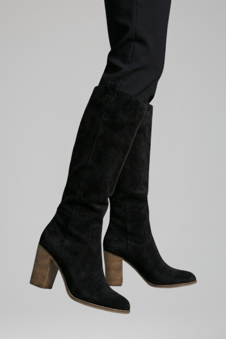 Black knee-high boots with wooden heel on a light gray background
